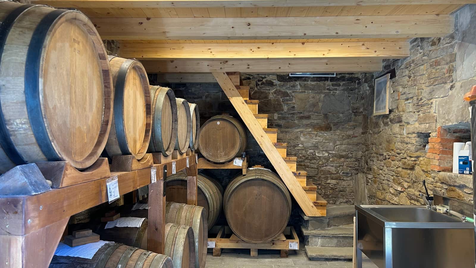 La sala delle botti dell'acetaia Gargeto, con le botti di legni diversi e la scala di legno